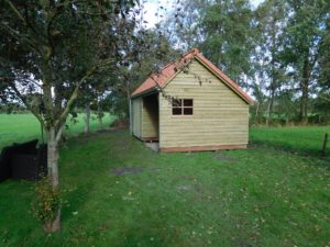 Houten berging met rode dakpannen
